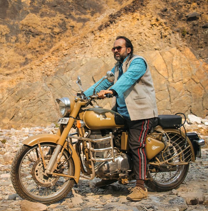 AP on a Royal Enfield motorcycle in mountains