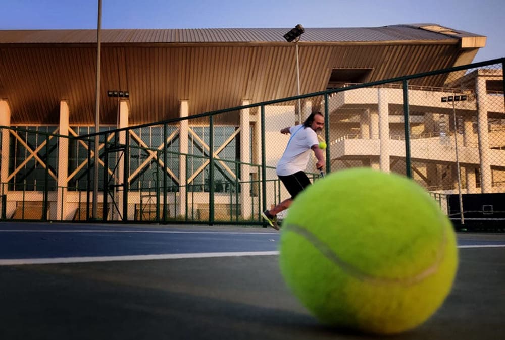 AP Playing tennis in a tennis court
